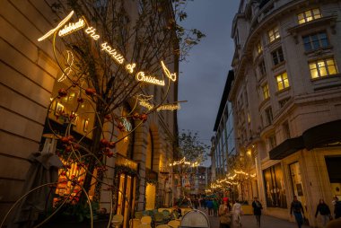 Londra, İngiltere - 20 Kasım 2023: Piccadilly Circus 'un hemen dışındaki Glasshouse Caddesi, Londra şehir merkezi. İnsanlar Noel ışıklarıyla sokakta yürüyorlar..