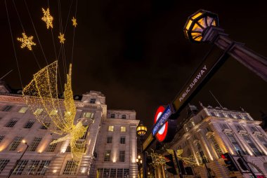 London, UK - Nov 20 2023: Looking up at buildings on Piccadilly Circus and Regent Street St James's. With Christmas lights and Piccadilly Circus underground station entrance. clipart