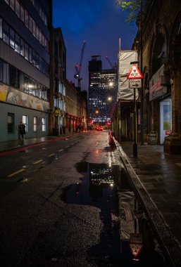 Bermondsey, London, UK: View along Crucifix Lane towards Guy's Hospital at night in the London borough of Southwark. clipart