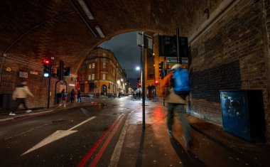 Bermondsey, London, UK: Bermondsey Street exiting a road tunnel under the London Bridge to Greenwich Railway Viaduct with pedestrians. clipart