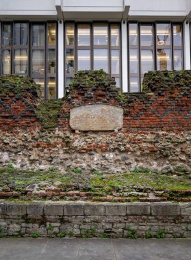 Londra, İngiltere: Antik Londra şehir duvarının bir parçası. Bu, temeli Roma kalesi olan ve 1477 'de eklenmiş tuğladan bir korkulukla kaplı bir ortaçağ duvarı. Portre yönelimi.