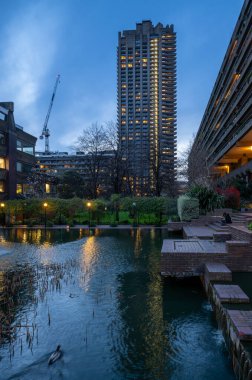 London, UK: Lauderdale Tower, artificial pond and gardens on the Barbican Estate in the City of London. The Barbican Estate is a prominent example of Brutalist architecture in London. clipart