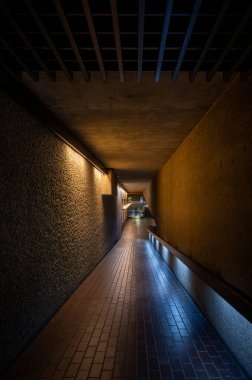 London, UK: Interior architecture of the Barbican Estate in the City of London with ramp walkway. The Barbican Estate is a prominent example of Brutalist architecture in London. clipart