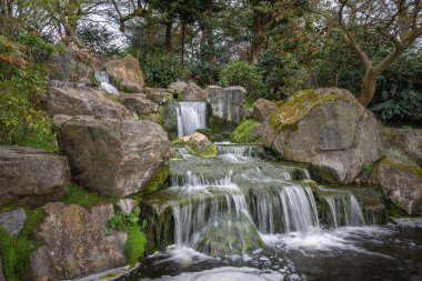 Kyoto Garden 'da şelale, Holland Park, Londra, İngiltere' de bir Japon bahçesi. Holland Park, Londra 'nın Kensington ilçesinde orman ve bahçeli bir parktır..