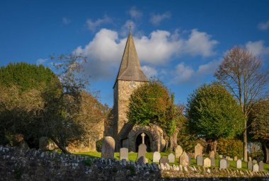 Burwash, Doğu Sussex, UK: Burwash 'daki St. Bartholomew Kilisesi mezarlık, ağaçlar ve duvarlarla.