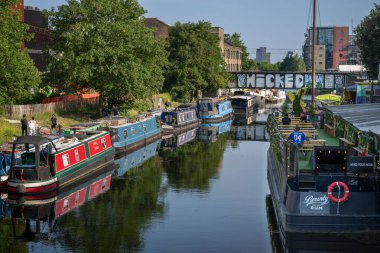 Hackney Wick, Londra, İngiltere: Doğu Londra 'da Hackney Wick' te bir kanal olan Lee Nehri 'ne demirlemiş tekneler (navigasyon). Yol boyunca yürü ve kanal kenarındaki bir barda dur..