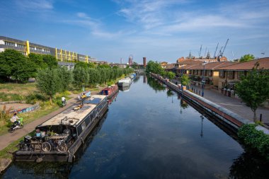 Hackney Wick, Londra, İngiltere: Doğu Londra 'nın Hackney Wick şehrinde, sahil yolunda bisikletçilerle dolu bir kanal olan Lee Nehri' ne demirlemiş tekneler (navigasyon).
