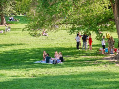Viyana, Avusturya - Haziran 2022: Viyana 'daki Burggarten parkında insanlar, turistler ve yerel halk dinleniyor ve yeşil çimlerde eğleniyorlar.