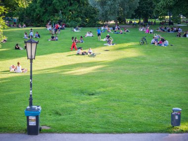 Viyana, Avusturya - Haziran 2022: Viyana 'daki Burggarten parkında insanlar, turistler ve yerel halk dinleniyor ve yeşil çimlerde eğleniyorlar.