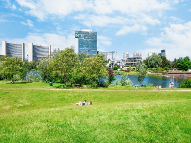 Viyana, Avusturya - Haziran 2022: Viyana 'da Birleşmiş Milletler Ofisi' ne ev sahipliği yapan bina kompleksiyle Kaiserwasser Alte Donau parkından görüntü