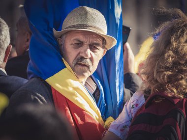 Bükreş, Romanya - Ekim 2022: Bükreş 'teki Üniversite Meydanı' nda düzenlenen bir gösteride Romanya ulusal bayrağını tutan kıdemli adam. Romanya ulusal günü geçit töreni.