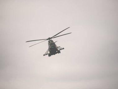 Bulutlu bir gökyüzünde uçan askeri helikopter. Hava gösterisi gösterisi.