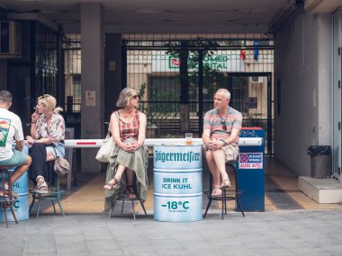 Bükreş, Romanya - Ağustos 2022: Bükreş 'in eski şehir merkezinde orta yaşlı bir çiftin masaya oturup bira içtiği şehir sahnesi.