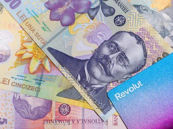 Revolut credit or debit card and many romanian banknotes on black background. Romanian currency concept.