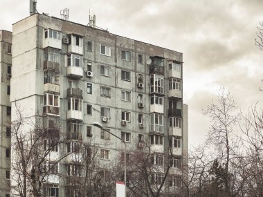 Bükreş 'teki mavi gökyüzüne karşı komünist dönemden kalma bir apartman binası. Çirkin geleneksel komünist konut topluluğu
