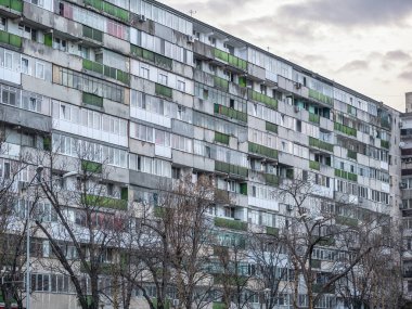 Bükreş 'teki mavi gökyüzüne karşı komünist dönemden kalma bir apartman binası. Çirkin geleneksel komünist konut topluluğu