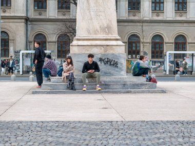 Bükreş, Romanya - 02.25.2023: Bükreş şehir merkezindeki Üniversite Meydanı 'nda çok sayıda insan ve turist
