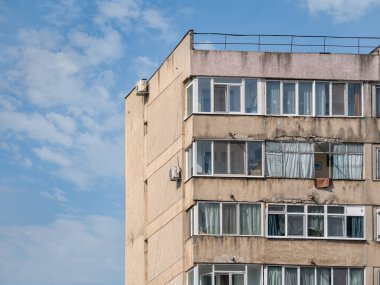 Bükreş 'teki mavi gökyüzüne karşı komünist dönemden kalma bir apartman binası. Çirkin geleneksel komünist konut topluluğu