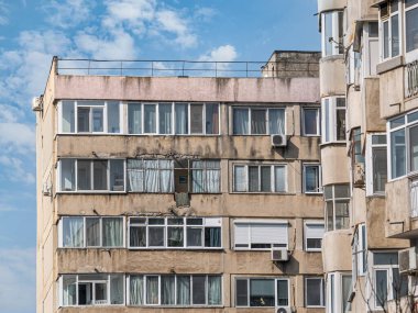 Bükreş 'teki mavi gökyüzüne karşı komünist dönemden kalma bir apartman binası. Çirkin geleneksel komünist konut topluluğu