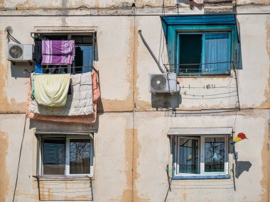 Romanya 'nın Bükreş kentinde eski, yıpranmış komünist apartman. Balkonda kurutulması gereken eski çamaşırlar..