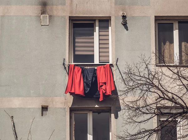 stock image Old worn out communist apartment building in Bucharest, Romania. Old clothes laundry left to dry on the balcony.