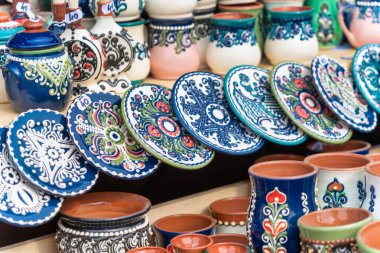 Geleneksel Romen el yapımı seramik çömlek tabakları ve kırsal otantik dekorasyon tabloları sergileniyor.