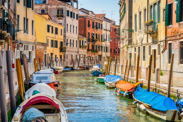 狭い運河に多くのボートが停まっているヴェネツィアからのカラフルな絵のシーン — ストック写真