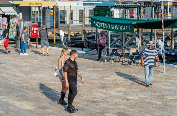 stock image Venice, Italy - May 29 2023: Gondolier approaching a young tourist couple for a gondola ride in Venice.