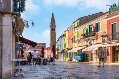 Venedik 'teki Burano adasında Saint Martin Piskoposu Kilisesi' nin yakınındaki çan kulesi olan deniz kanalı boyunca renkli evler..