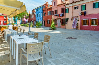 Venedik, Burano adasında açık hava restoranları ve renkli binaları olan küçük bir Piazzetta..