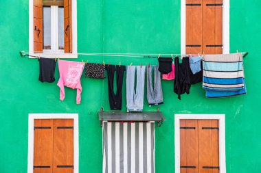 Burano Adası, Venedik 'teki renkli evlerin olduğu sakin bir manzara. Çamaşırları kurumaya bırakmış.