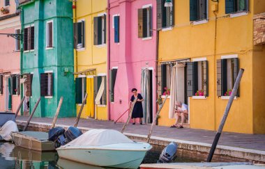 Venedik, İtalya - 30 Mayıs 2023: Burano, İtalya 'dan sabah geleneksel resim sahnesi. Renkli Burano adasının kıdemli sakinleri..