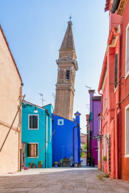 Venedik 'teki Burano adasında Saint Martin Piskoposu Kilisesi' nin yakınındaki çan kulesi olan deniz kanalı boyunca renkli evler..