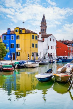 Venedik, İtalya - 30 Mayıs 2023: Venedik 'teki Burano adasında Saint Martin Piskoposu Kilisesi' nin yakınındaki çan kulesi olan su kanalı boyunca renkli evler.