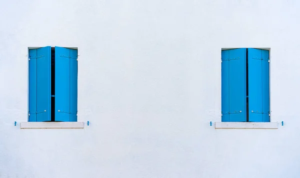 stock image Detail with a house window with blue painted wooden shutters in Burano, Italy.