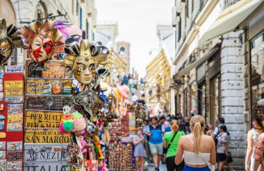 Venedik 'te karnaval maskesi satan turist kalabalığı ve hediyelik eşya dükkanlarıyla dolu bir yaya bölgesi..