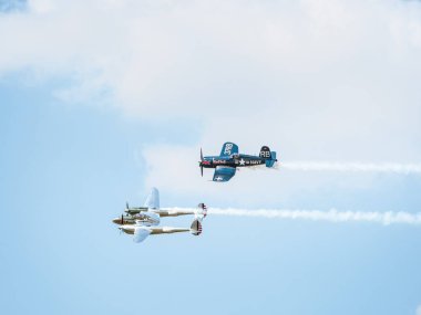 Bükreş, Romanya - Mayıs 2023: LOCKHEED P-38 Işıklandırma ve Şans F4U Corsair savaş uçakları Uçan Boğalar filosunun bir bölümü gökyüzüne doğru uçuyordu.