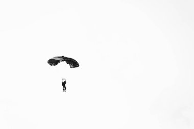 Beyaz arkaplanda paraşüt atlayıcısı olan soyut minimal resim.