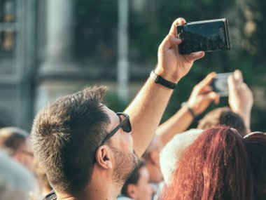 Bükreş, Romanya - 17 Haziran 2023: Bükreş 'in merkezinde fotoğraf çeken akıllı telefonlu mutlu turist