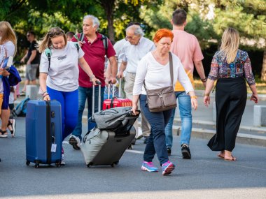 Bükreş, Romanya - 17 Haziran 2023: Bükreş şehir merkezindeki Zafer Caddesi 'nde (Calea Victoriei) seyahat bavulu ve bavulu bulunan turist ailesi.