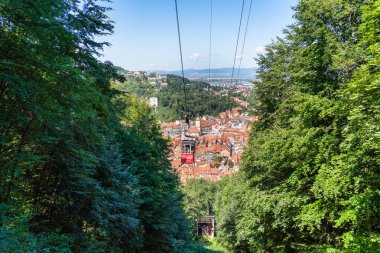 Brasov, Romanya - 02 Eylül 2023: Arka planda Brasov kentiyle Tampa Dağı zirvesine giden kablolu otomobil.