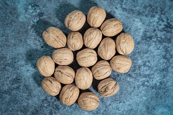 Mavi arka planda kabuklu ceviz. Taze organik fındık. Üst genel görünüm.