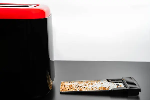 Tost makinesinin ekmek kırıntılarıyla dolu bir tepsi.