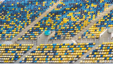 Boş bir stadyum arenasında renkli koltuklar. Ayrıntıları kapat