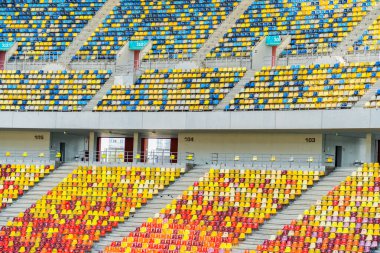 Boş bir stadyum arenasında renkli koltuklar. Ayrıntıları kapat