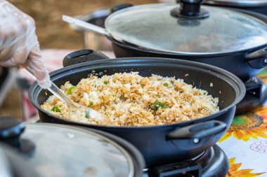 Elle servis edilen kızarmış Kore pirinci. Asya sokak yemekleri.