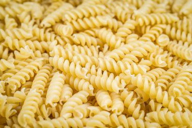 Bir yığın çiğ İtalyan fusilli spiral makarna. Doku arkaplanı.