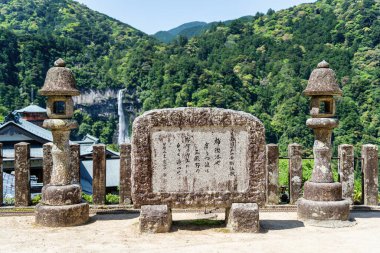 Nachi-Katsuura, Japan -05.09.2024: Beautiful view with Nachi Waterfall and a commemorative stone with ancient Japanese writings. clipart