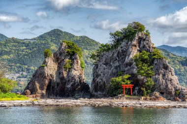 Japonya, Nachikatsuura 'daki Bentenjima adasında izole edilmiş bir tapınak. Pasifik kıyılarından manzaralı kayalık bir manzara.