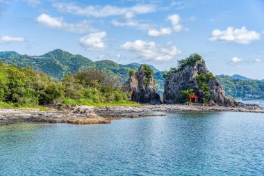 Japonya, Nachikatsuura 'daki Bentenjima adasında izole edilmiş bir tapınak. Pasifik kıyılarından manzaralı kayalık bir manzara.
